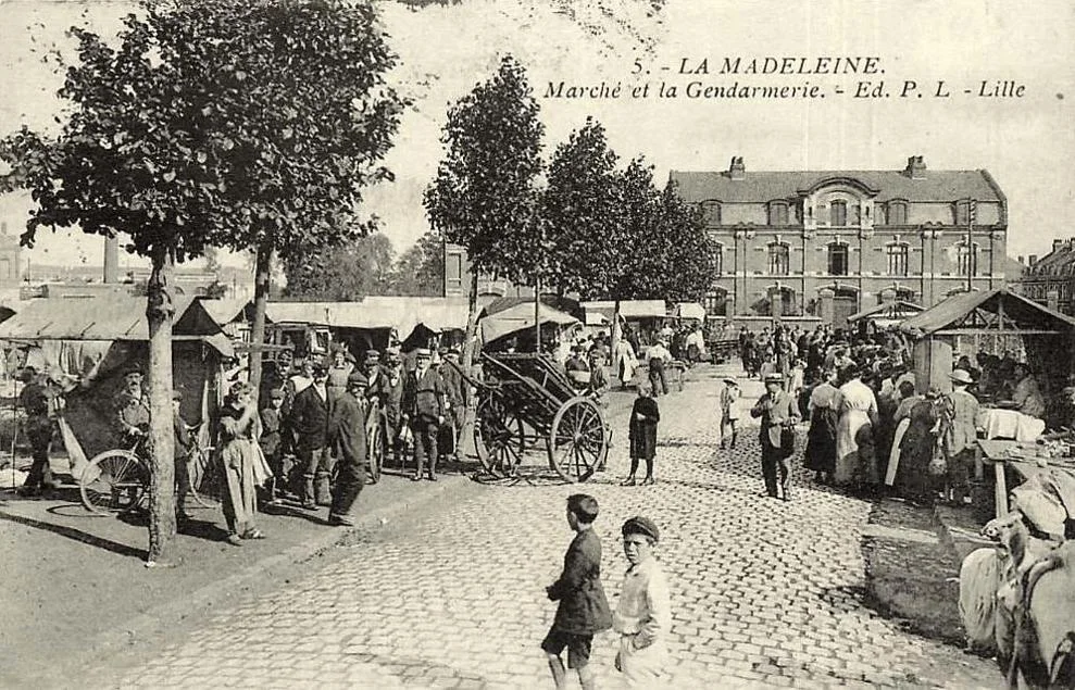 Le marché de La Madeleine sur une carte postale ancienne, avec la gendarmerie en arrière-plan. Ce document montre un état historique du lieu.